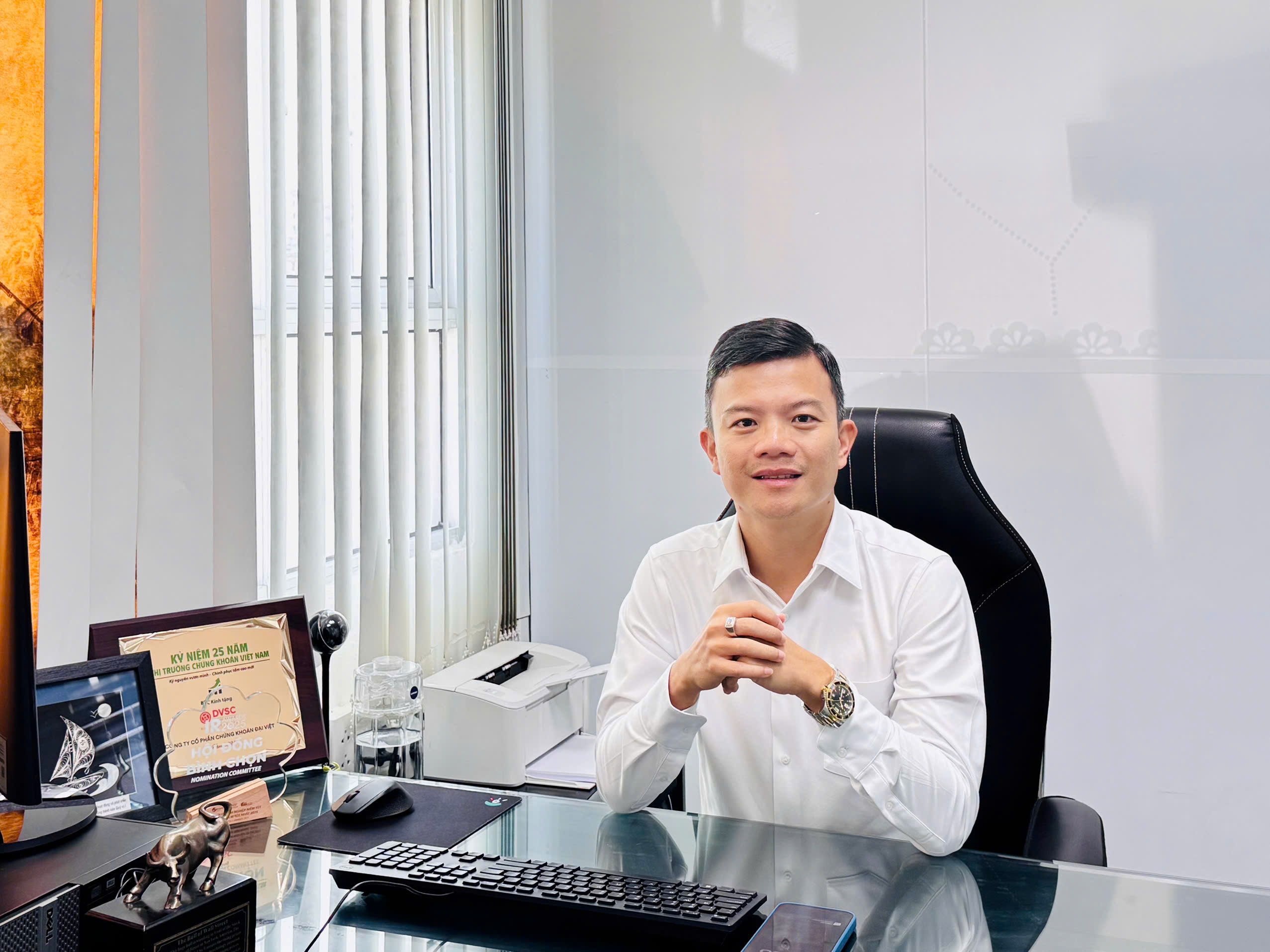 Ông Hồ Đức Toàn mặc sơ mi trắng tại bàn làm việc